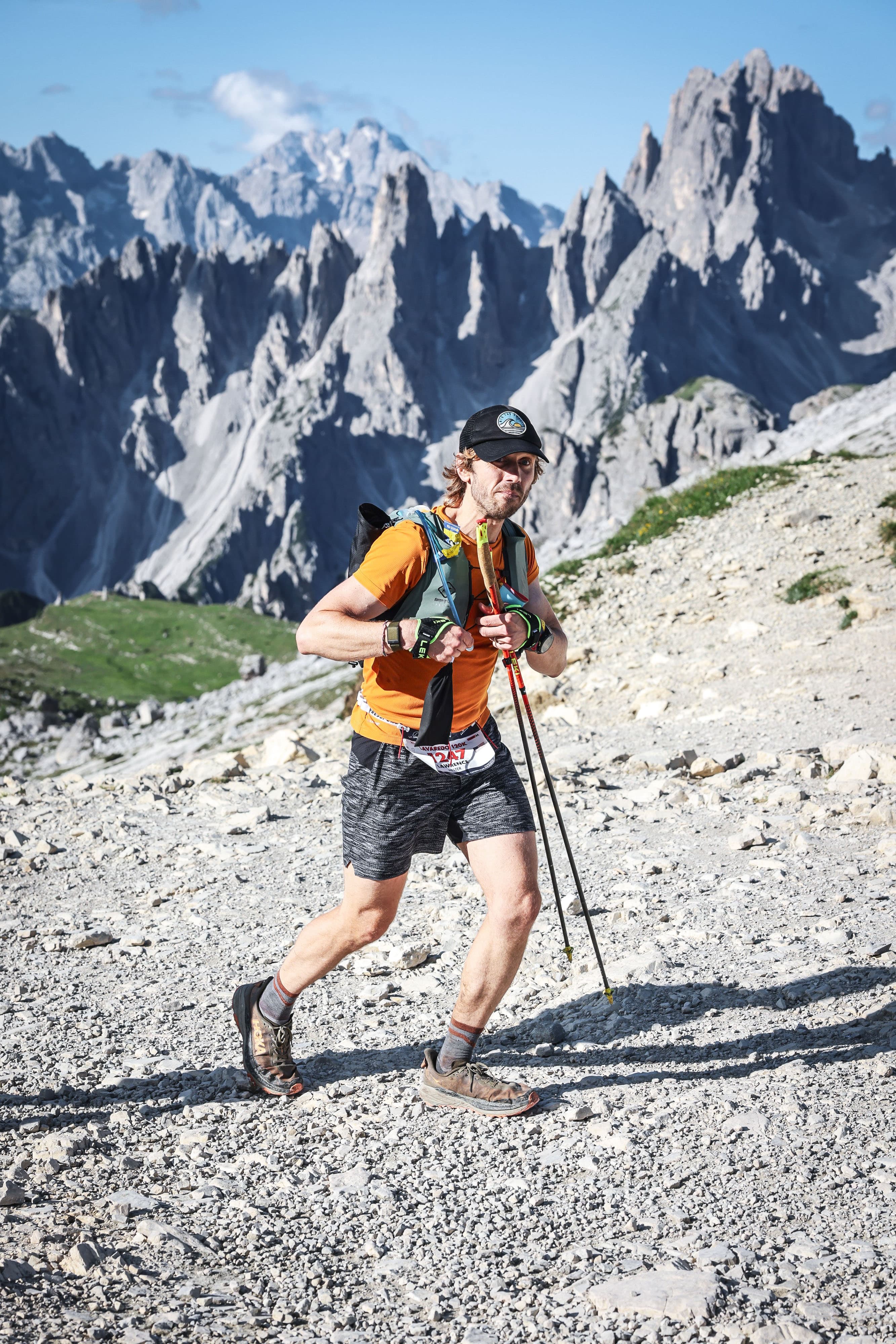 Runner pushing through scree below jagged peaks
