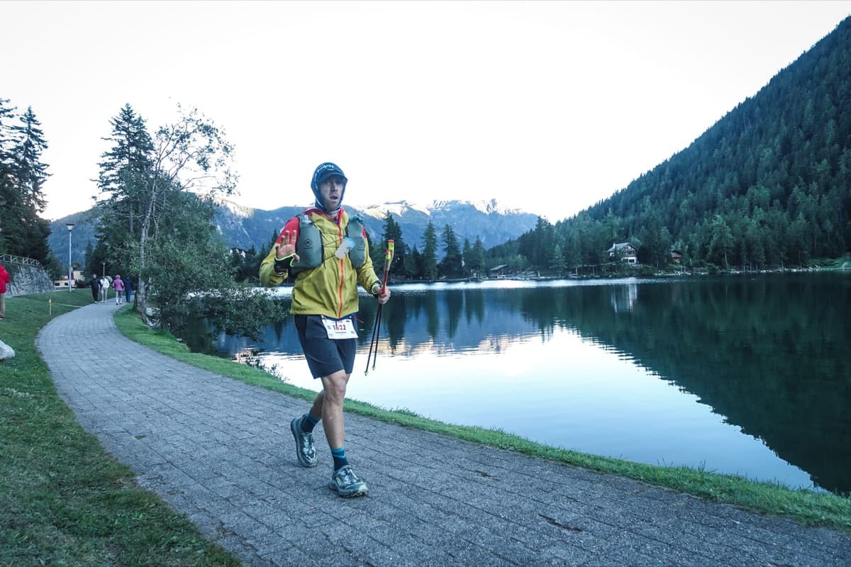 Runner along a mountain lakeside at dusk